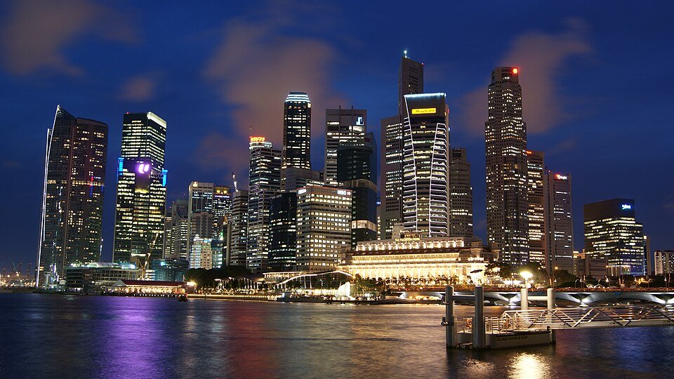 Singapore financial district skyline illuminated against a deep blue evening sky